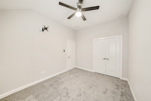 unfurnished bedroom with ceiling fan, light carpet, a closet, and vaulted ceiling