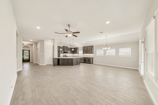 unfurnished living room with light hardwood / wood-style floors and ceiling fan with notable chandelier