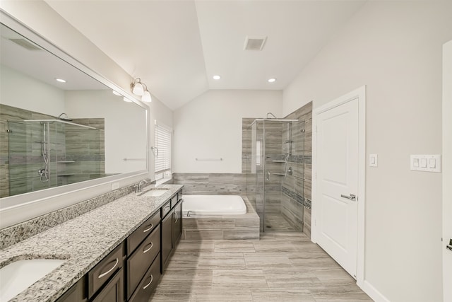 bathroom featuring vanity, plus walk in shower, and vaulted ceiling