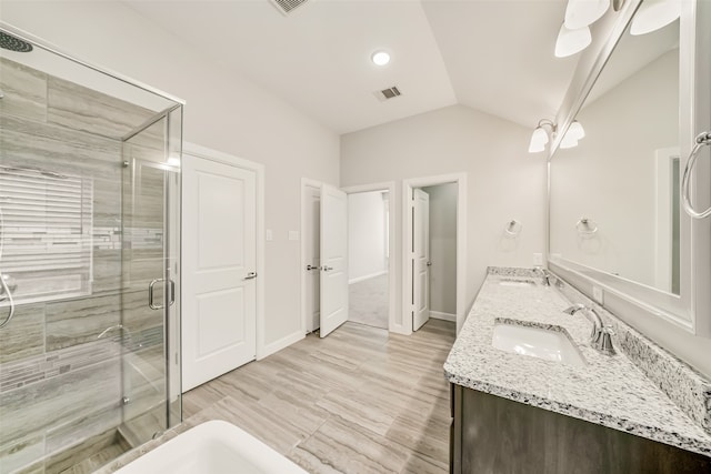 bathroom featuring vanity, vaulted ceiling, hardwood / wood-style flooring, and a shower with door