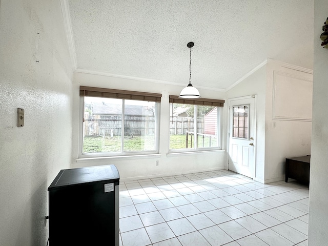 interior space with lofted ceiling, a textured ceiling, light tile patterned flooring, and crown molding