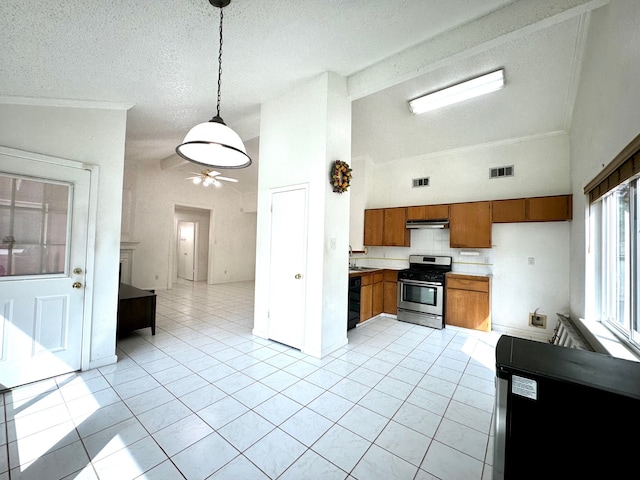 kitchen with ceiling fan, a textured ceiling, decorative light fixtures, and stainless steel range oven