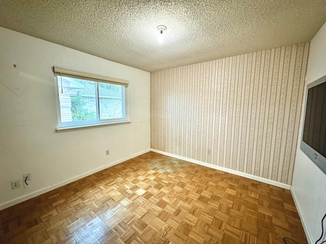 empty room featuring a textured ceiling and parquet floors