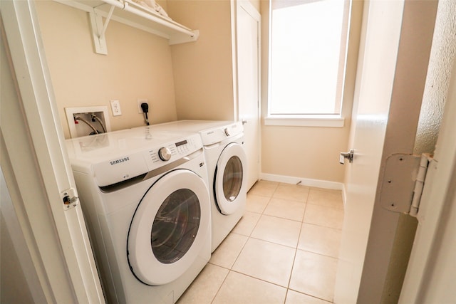 washroom with light tile patterned floors and washer and clothes dryer