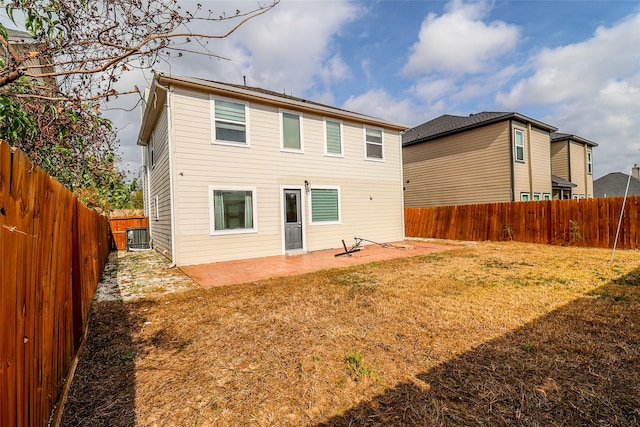 back of house featuring a lawn, cooling unit, and a patio