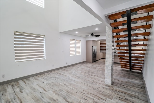 unfurnished living room with ceiling fan and light hardwood / wood-style floors