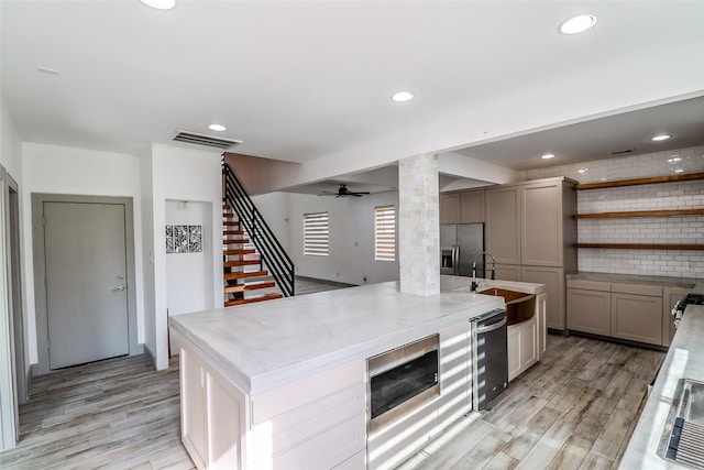 kitchen featuring sink, wine cooler, ceiling fan, appliances with stainless steel finishes, and light hardwood / wood-style floors