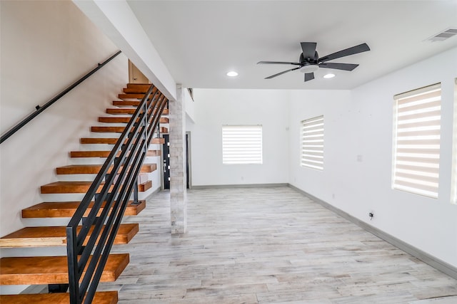 stairs featuring a wealth of natural light, ceiling fan, and hardwood / wood-style flooring