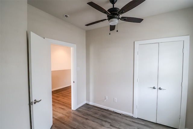 unfurnished bedroom with ceiling fan, a closet, and hardwood / wood-style flooring