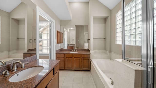 bathroom with a relaxing tiled tub, vanity, a healthy amount of sunlight, and lofted ceiling