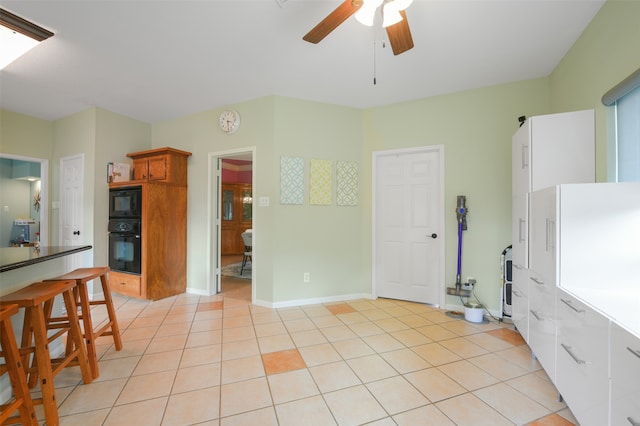 kitchen with black appliances, ceiling fan, and light tile patterned floors