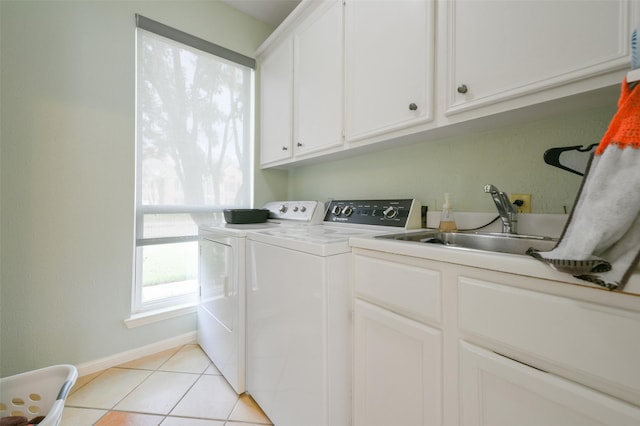 laundry room featuring cabinets, light tile patterned floors, washing machine and dryer, and sink