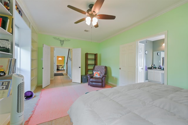 tiled bedroom featuring ceiling fan, crown molding, and ensuite bath