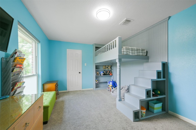 bedroom featuring light carpet and a textured ceiling