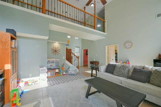 living room featuring tile patterned flooring, a towering ceiling, and ceiling fan