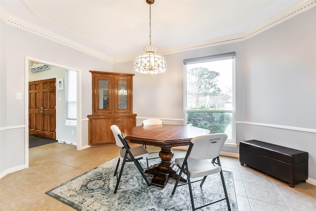 tiled dining area featuring ornamental molding and an inviting chandelier