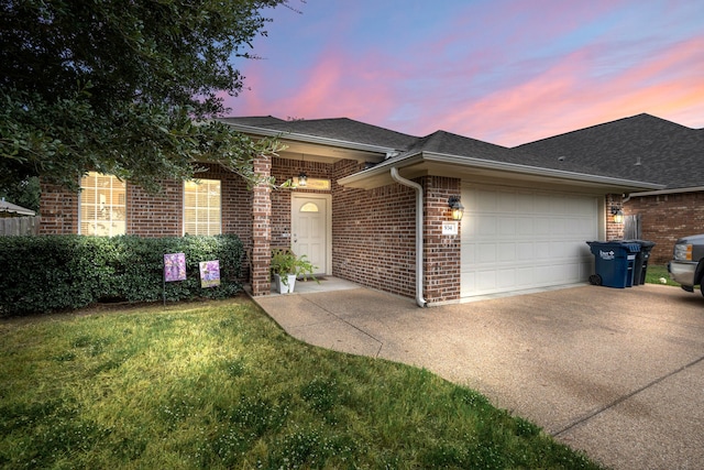 ranch-style home featuring a garage and a lawn