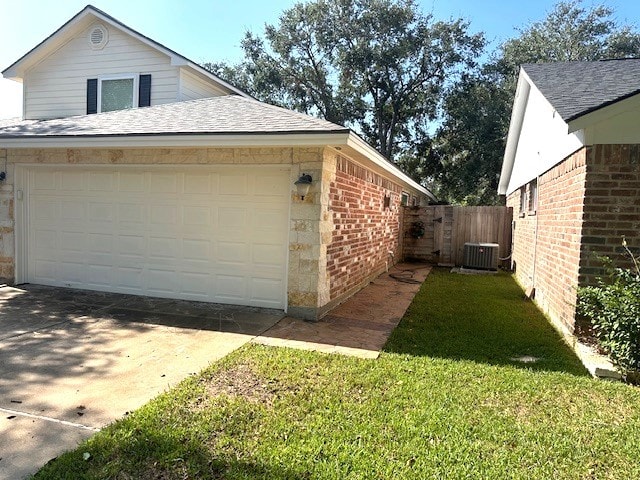 view of home's exterior with central AC, a yard, and a garage