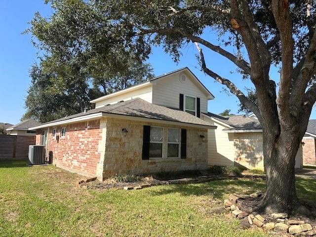 exterior space with central AC unit and a lawn