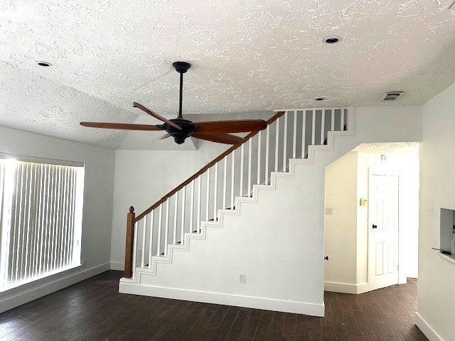 staircase featuring hardwood / wood-style floors, a textured ceiling, and ceiling fan