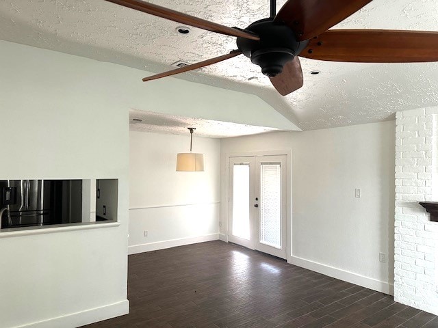 unfurnished living room with lofted ceiling, ceiling fan, a textured ceiling, and dark hardwood / wood-style flooring