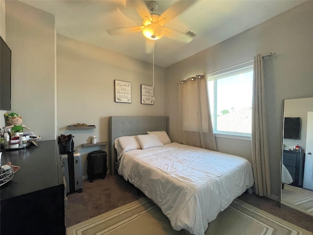 bedroom featuring ceiling fan and dark carpet