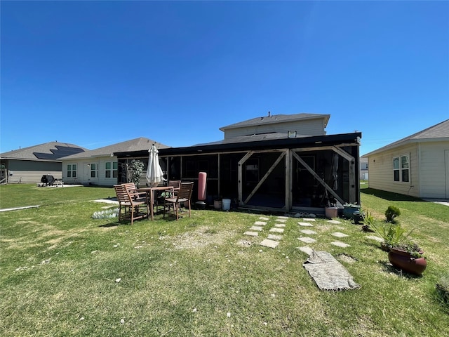 rear view of property featuring a sunroom, a patio, and a yard