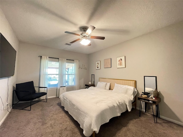 carpeted bedroom with a textured ceiling and ceiling fan