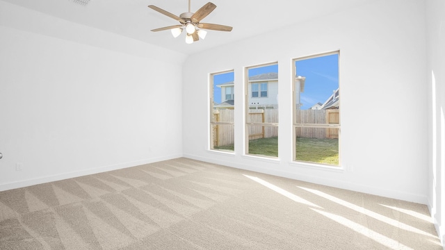 spare room featuring ceiling fan, vaulted ceiling, and light carpet