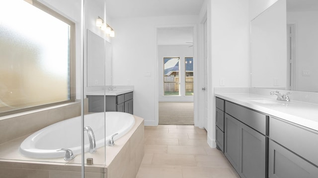 bathroom with tiled tub, tile patterned floors, and vanity