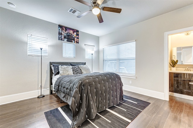 bedroom with hardwood / wood-style floors, ceiling fan, connected bathroom, and sink