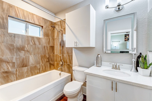 full bathroom with toilet, vanity, and tiled shower / bath