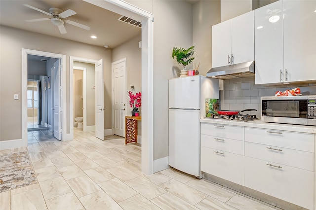 kitchen with stainless steel appliances, ceiling fan, white cabinetry, and decorative backsplash