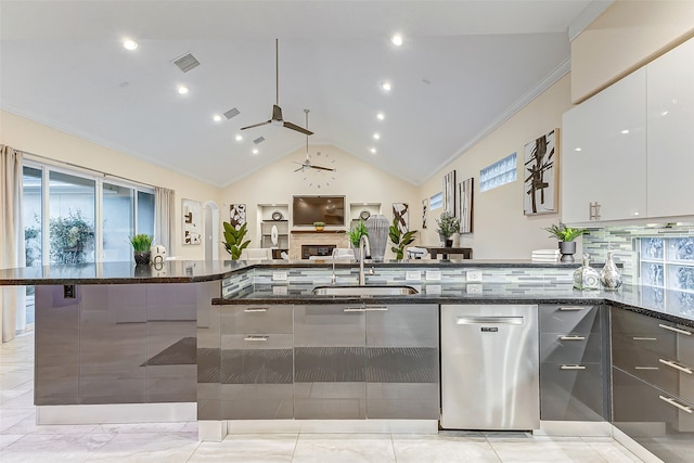 kitchen featuring white cabinets, a wealth of natural light, dark stone counters, and dishwasher