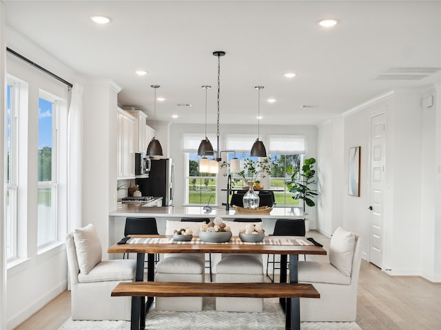 dining room featuring crown molding and light hardwood / wood-style flooring