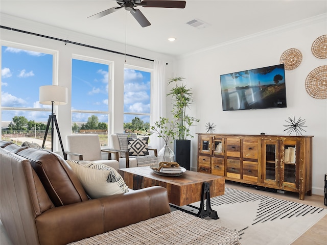 living room with light wood-type flooring, ceiling fan, and ornamental molding