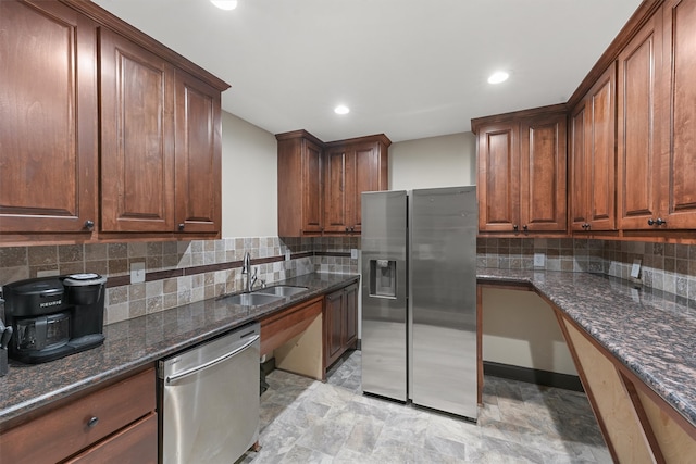 kitchen featuring dark stone counters, tasteful backsplash, appliances with stainless steel finishes, and sink