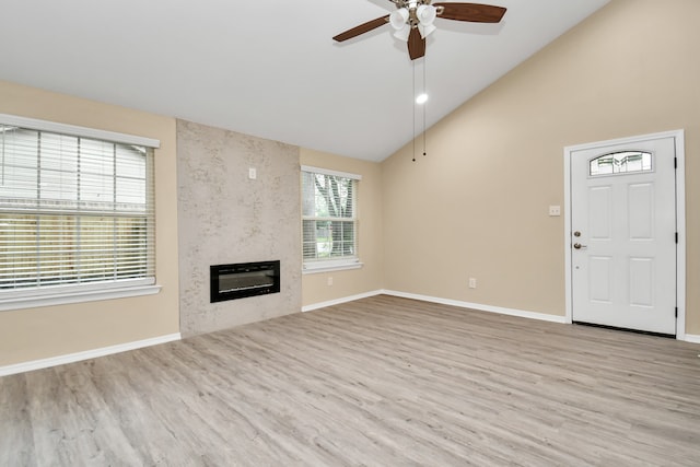 unfurnished living room featuring light wood-type flooring, a fireplace, ceiling fan, and high vaulted ceiling