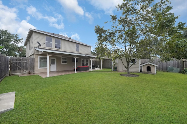 rear view of property featuring a yard, a shed, and a patio area