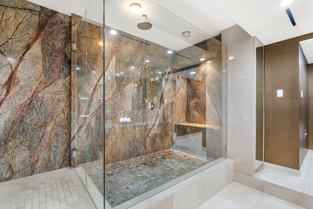 bathroom with tile walls, tile patterned floors, and tiled shower