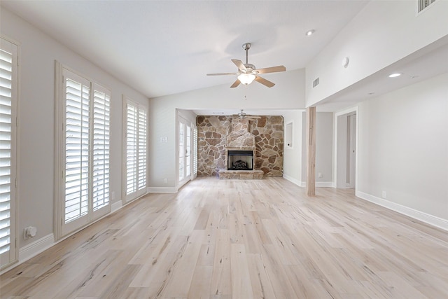 unfurnished living room featuring a fireplace, light wood finished floors, lofted ceiling, visible vents, and a ceiling fan