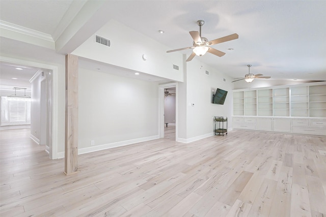 unfurnished living room with built in shelves, light wood finished floors, visible vents, vaulted ceiling, and baseboards