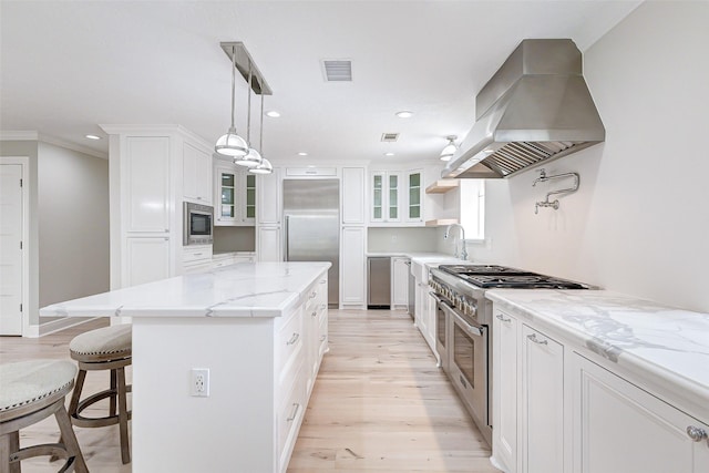 kitchen with range hood, a center island, visible vents, white cabinets, and built in appliances