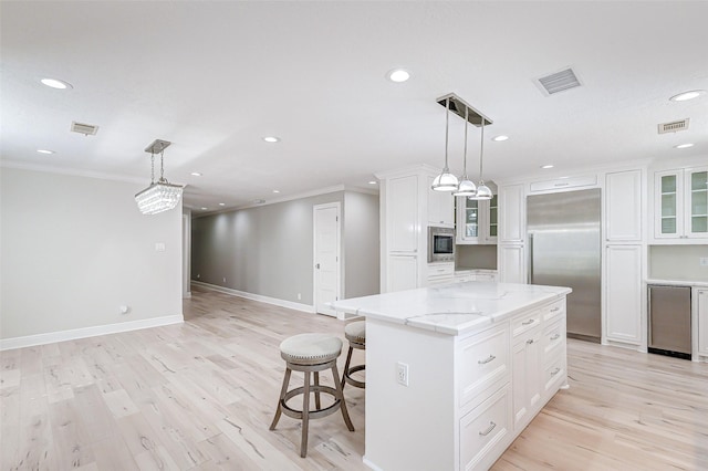 kitchen featuring built in appliances, glass insert cabinets, visible vents, and white cabinets