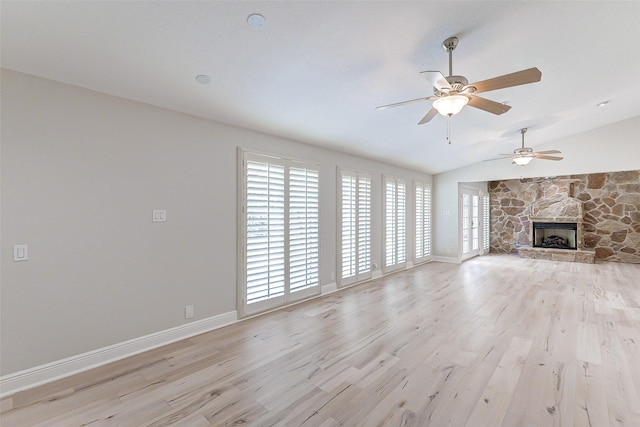 unfurnished living room featuring light wood-style flooring, a fireplace, baseboards, and vaulted ceiling