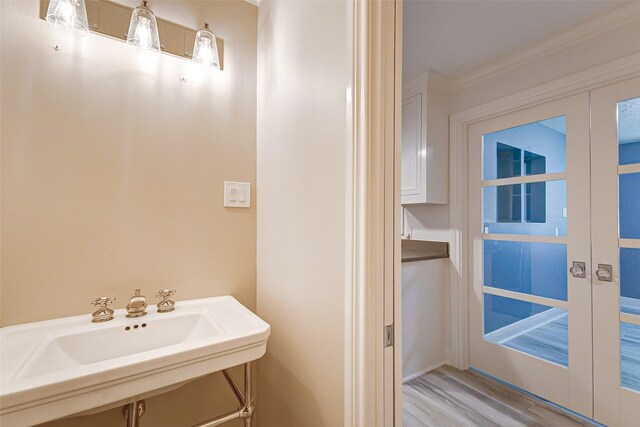 bathroom with wood finished floors, a sink, and french doors