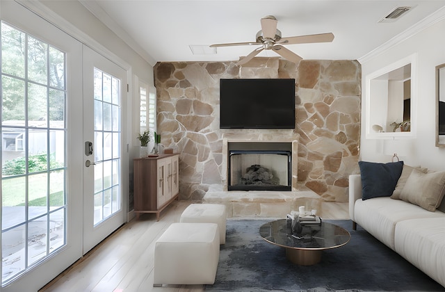 living room featuring a wealth of natural light, french doors, visible vents, and a fireplace