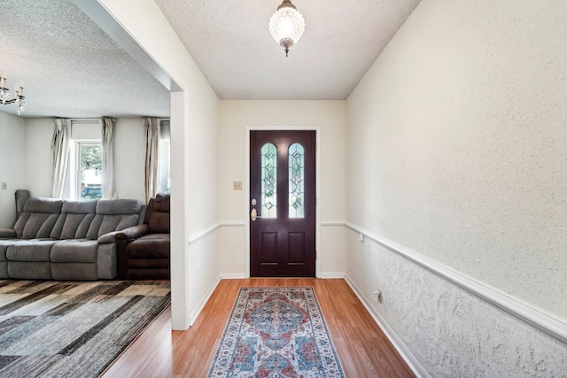 foyer entrance featuring a textured ceiling and light wood-type flooring