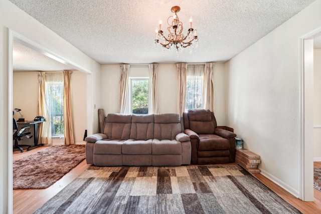 living room featuring hardwood / wood-style flooring, a textured ceiling, and a notable chandelier