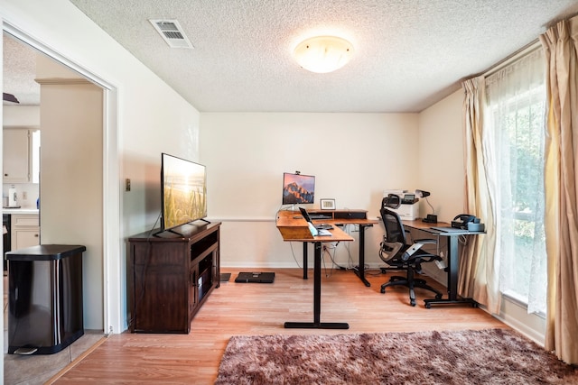 office space featuring light hardwood / wood-style flooring and a textured ceiling